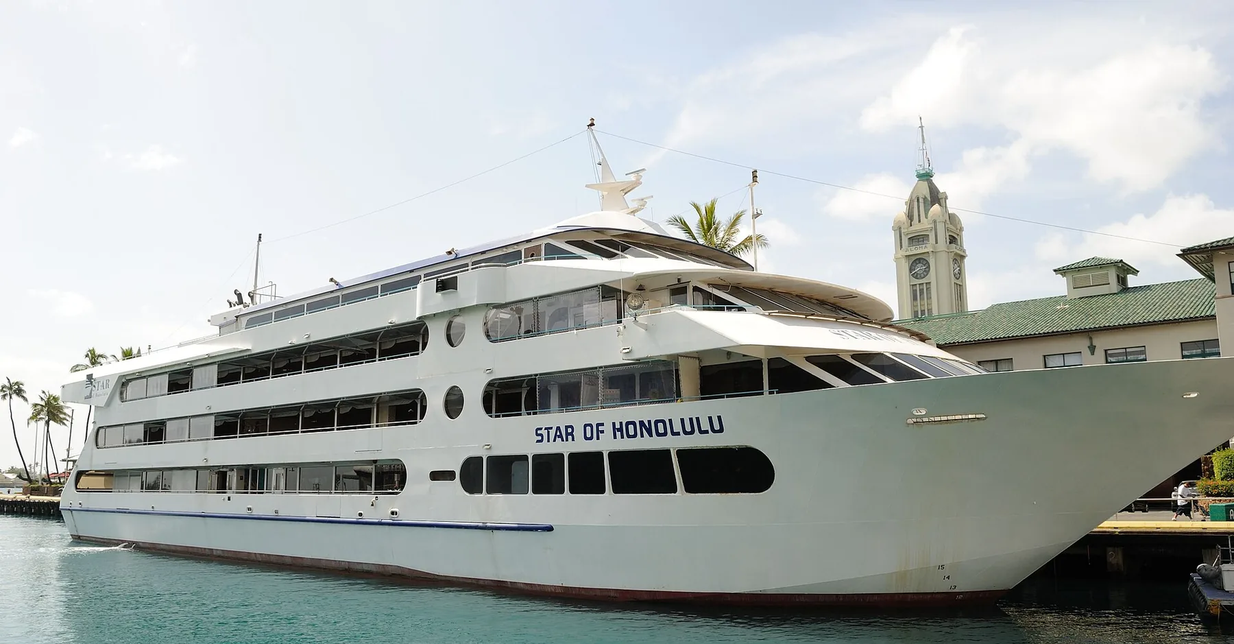 Die weiße Star of Honolulu mit vier Decks, festgemacht an ihrem Pier im Honolulu Harbor neben dem Uhrturm Aloha Tower